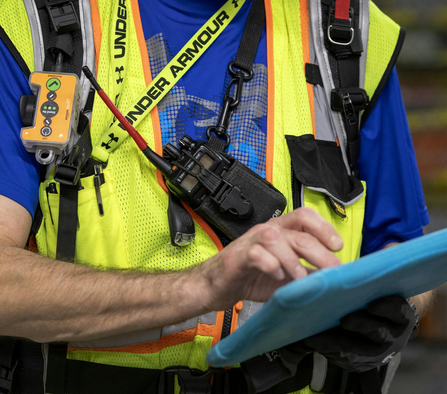 Mark Nelson wore an enhanced safety vest that communicates with Amazon Robotic drives and slows them down and even stops them when within a certain perimeter of him while the vest is active at the Amazon fulfillment center in Shakopee. ] CARLOS GONZALEZ &#x2022; cgonzalez@startribune.com &#x2013; Shakopee, MN &#x2013; May 8, 2019, Tour Amazon fulfillment center in Shakopee