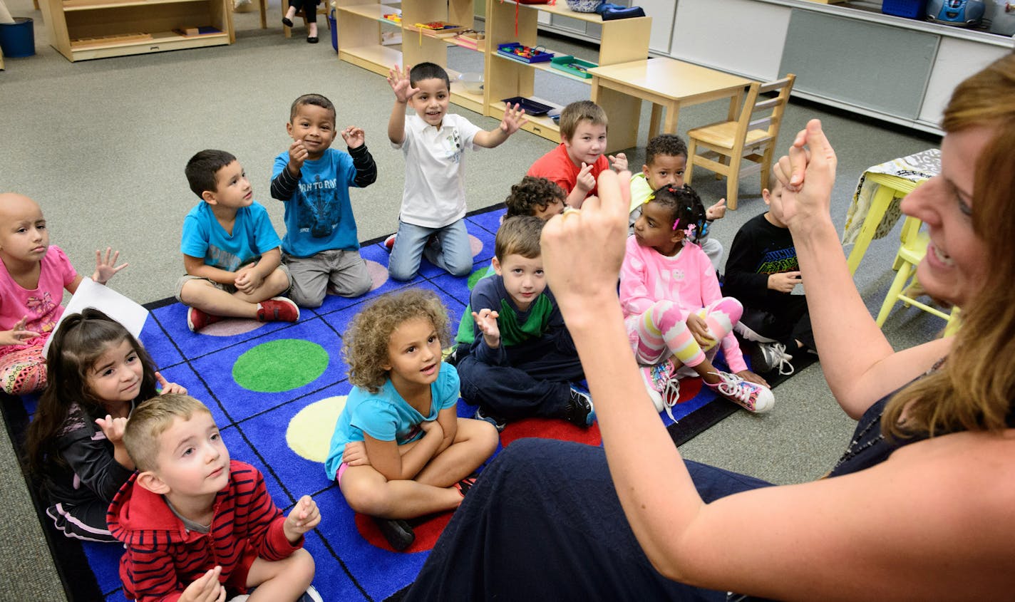 Montessori teacher Libby Boyd led her students in a song she created called "How Do We Sit" doing small physical actions like snapping their fingers as they sing helpijng focus their attention before they went to art class. ] GLEN STUBBE * gstubbe@startribune.com Thursday September 24, 2015 The Pre-K and Kindergarten Montessori program at Cherokee Heights Elementary, St. Paul.