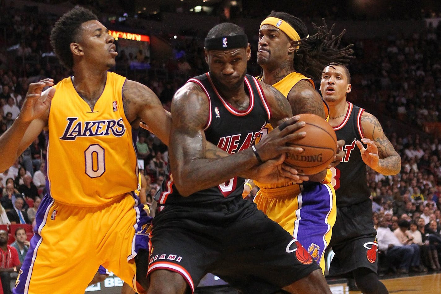 The Miami Heat's LeBron James drives against the Los Angeles Lakers' Nick Young (0) and Jordan Hill during the first quarter at the AmericanAirlines Arena in Miami on Thursday, Jan. 23, 2014. (David Santiago/El Nuevo Herald/MCT) ORG XMIT: 1148271