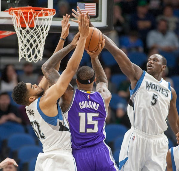 Sacramento Kings forward DeMarcus Cousins (15) shoots against Minnesota's Karl-Anthony Towns (32) and Gorgui Dieng during the first half of an NBA bas