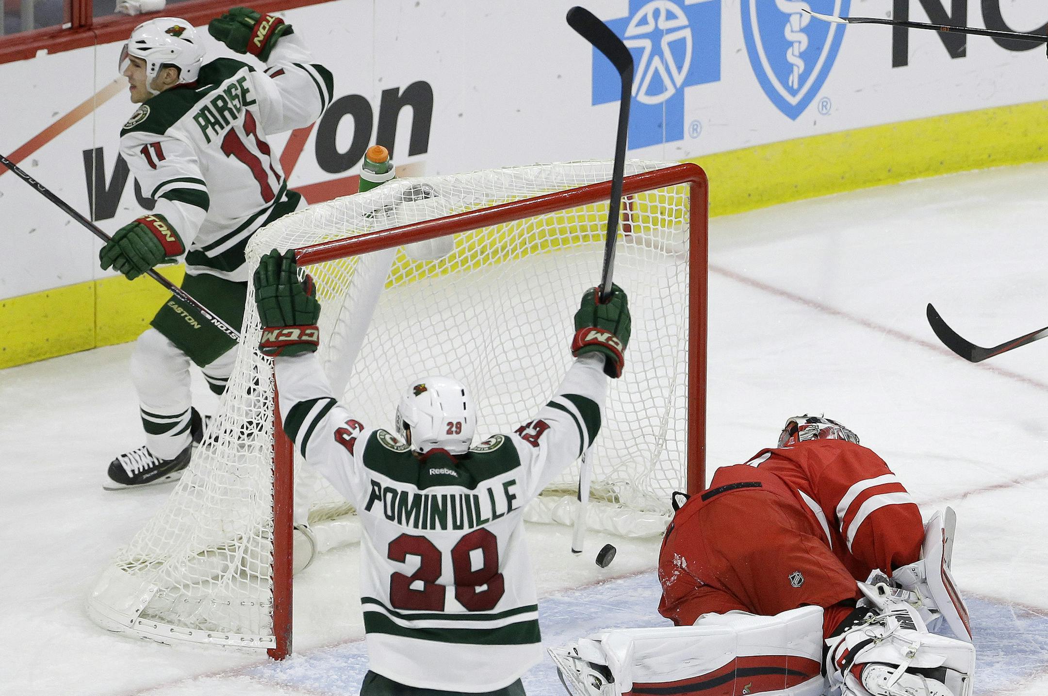 Minnesota Wild's Zach Parise (11) and Jason Pominville (29) celebrate Parise's goal against Carolina Hurricanes goalie Anton Khudobin, of Kazakhstan, during the third period of an NHL hockey game in Raleigh, N.C., Friday, March 6, 2015. Minnesota won 3-1. (AP Photo/Gerry Broome)