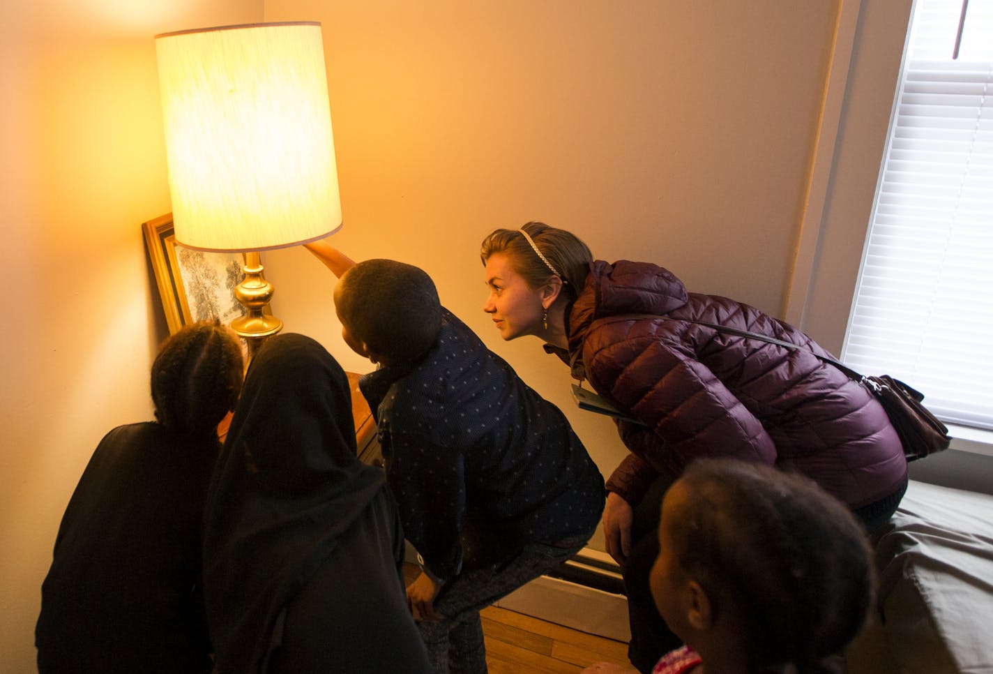 Case manager Katia Iverson helps the Abdullahi family through the steps of resettling in Minnesota, from renting a house to teaching the children how to turn on a lamp during their first home visit in Minneapolis.