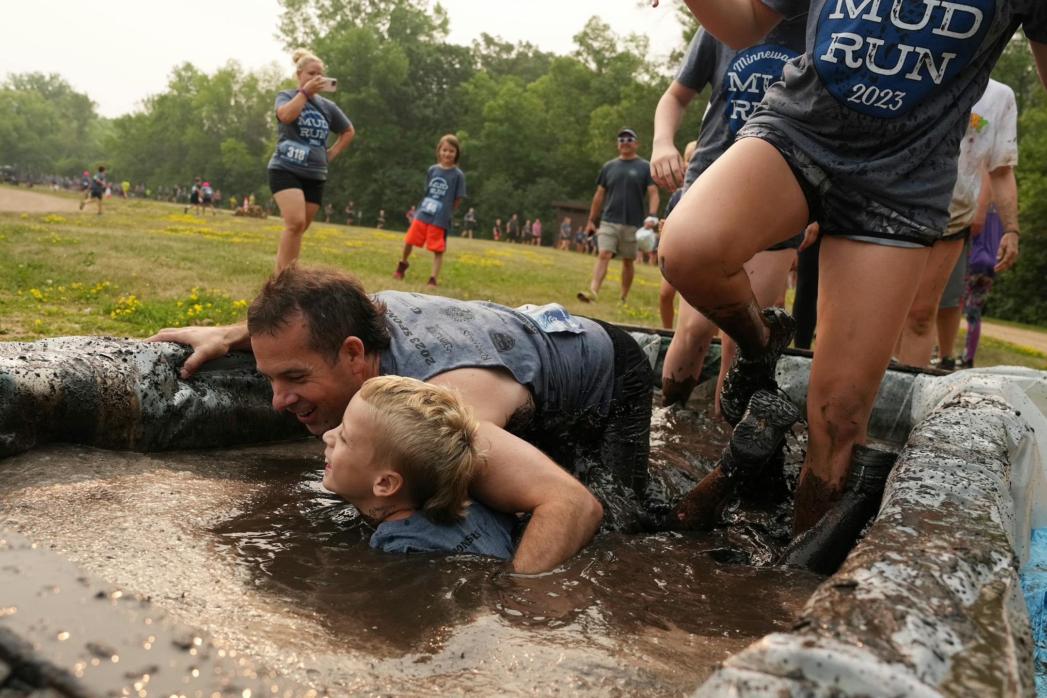 Runners splash their way through the first of the mud pits during the Minneswashta Mud Run.