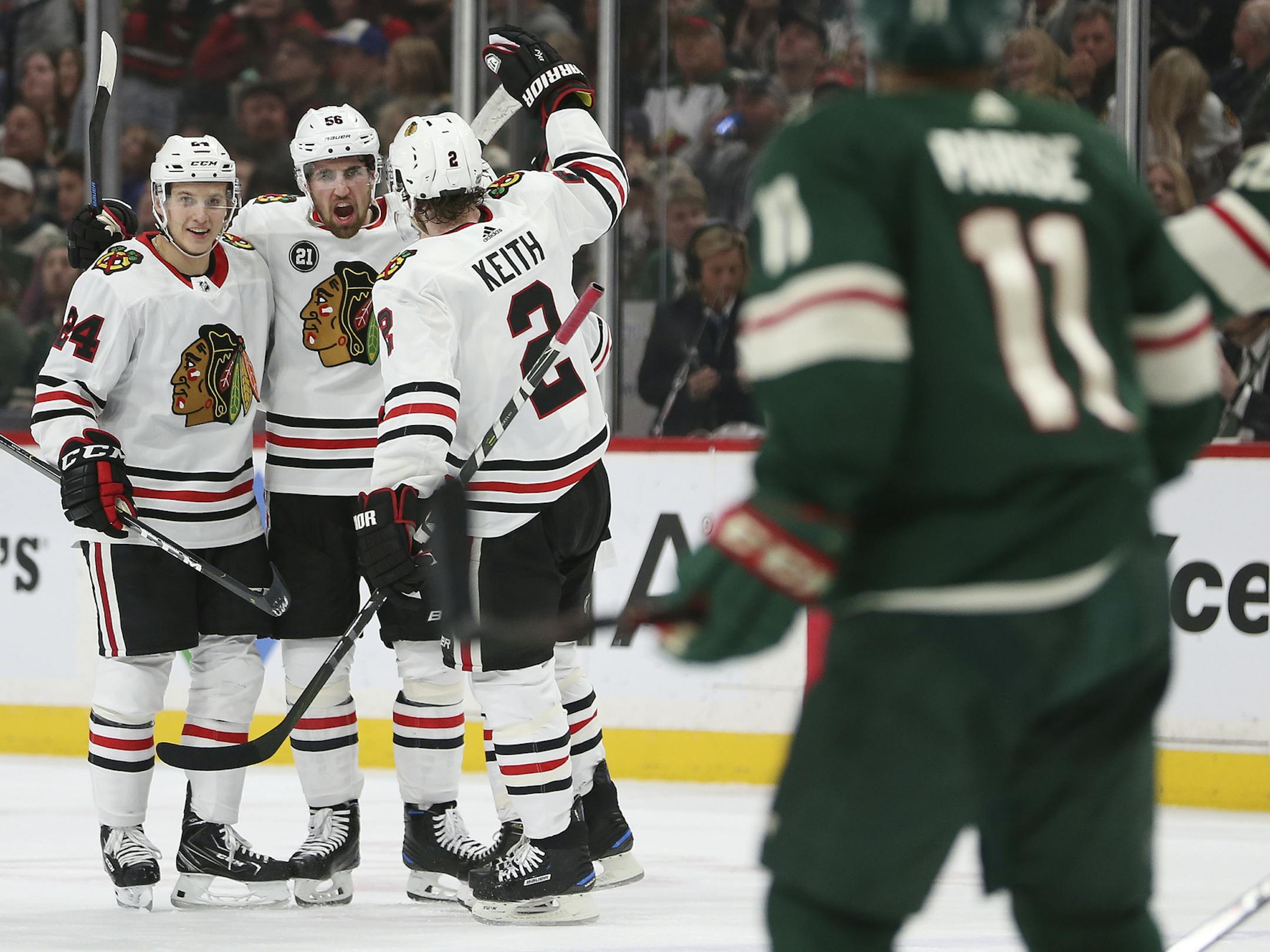 Chicago Blackhawks' Erik Gustafsson, middle, of Sweden, celebrates with teammates Dominik Kahun, left, of the Czech Republic, and Duncan Keith, right, after Gustafsson scored a goal against the Minnesota Wild during the second period of an NHL hockey game Saturday, Feb. 2, 2019, in St. Paul, Minn. (AP Photo/Stacy Bengs)