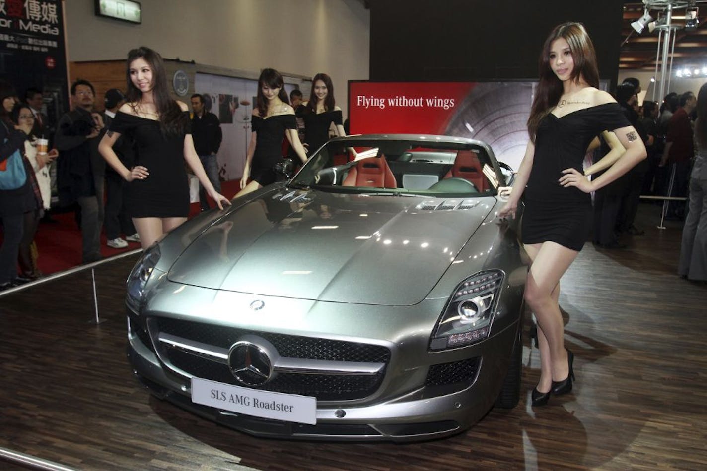 Models pose by Mercedes Benz SLS AMG Roadster on display during the 2012 Taipei International Auto Show at the Taipei World Trade Center in Taipei, Taiwan, Friday, Dec. 23, 2011.