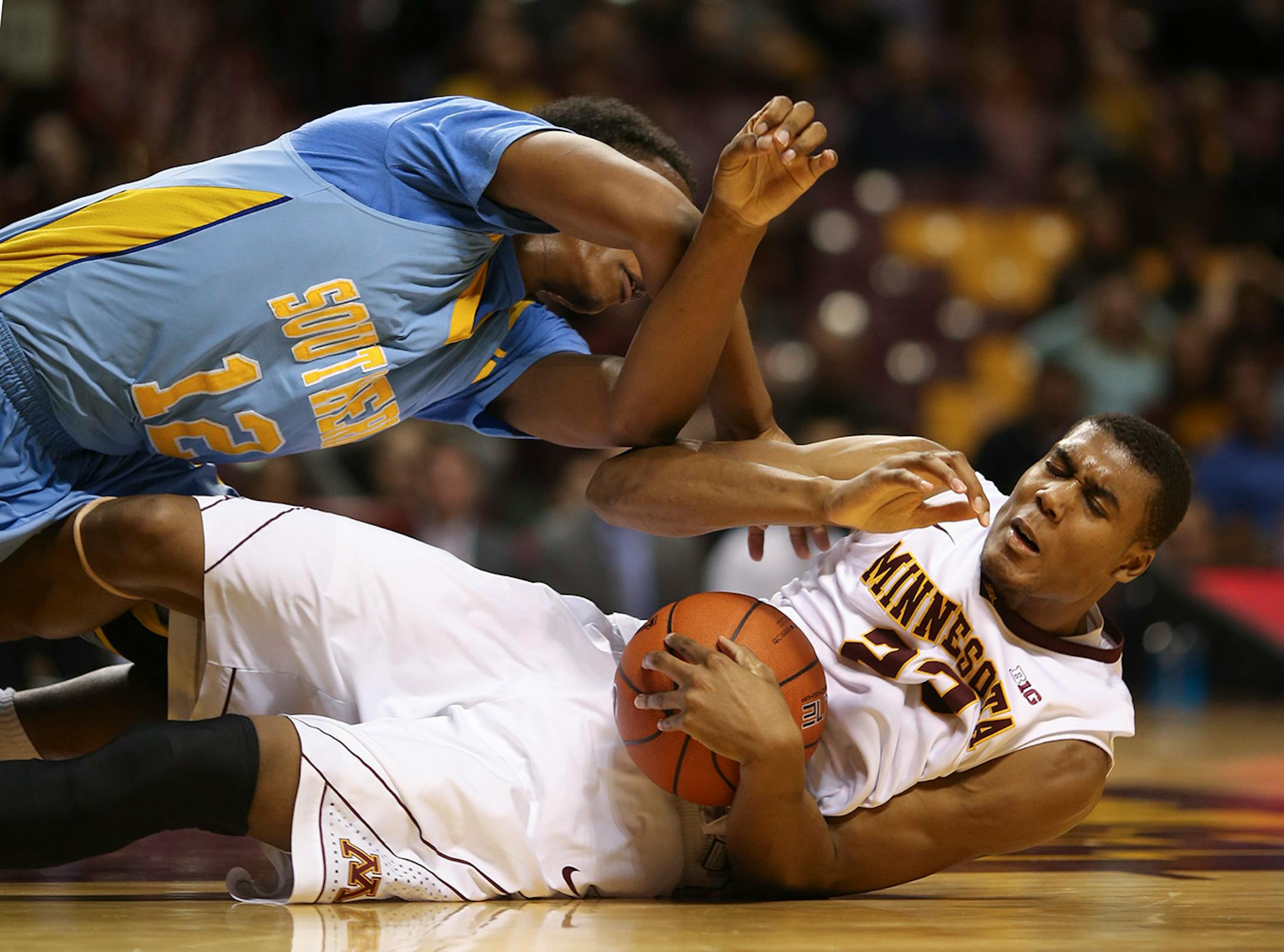 Southern University Jaguars forward Jared Sam landed on top of Gophers forward Charles Buggs as they crashed to the court in the second half Wednesday night at Williams Arena. ] JEFF WHEELER • jeff.wheeler@startribune.com The University of Minnesota men's basketball team trounced Southern University 85-57 at Williams Arena Wednesday night, December 10, 2014 in Minneapolis.