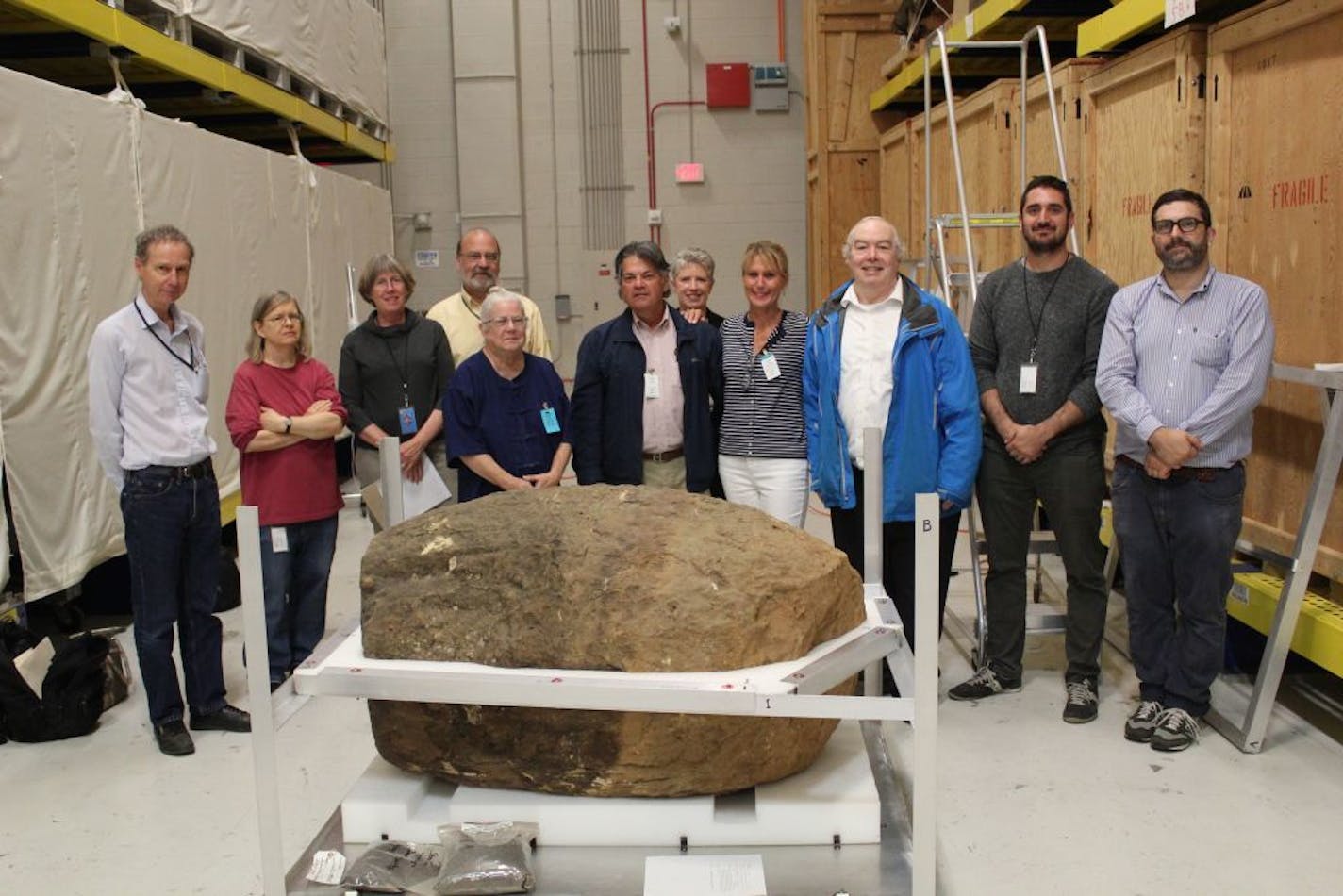 In September, researchers and visitors to the Smithsonian Institution warehouse in Suitland, Md., posed with the ancient sandstone jar given as a gift by Gen. Vang Pao in 1970.