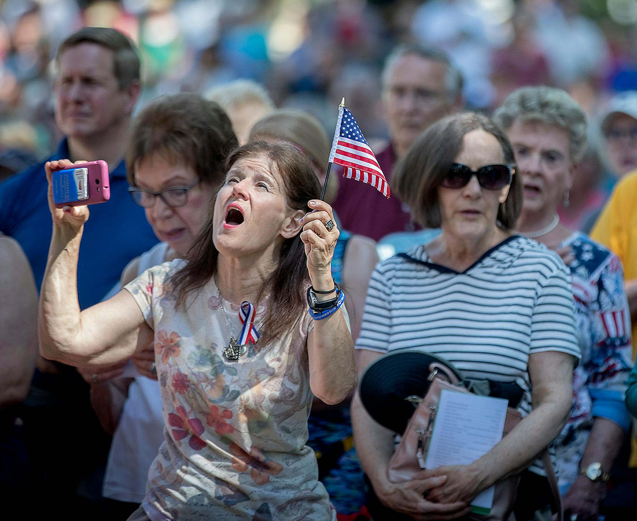 Merrilyn Downs, left, sang along as the band played the National Anthem at the annual Memorial Day Ceremony at Lakewood Cemetery, Monday, May 28, 2018 in Minneapolis, MN. Downs was there to honor her father who was a World War II Army Veteran.