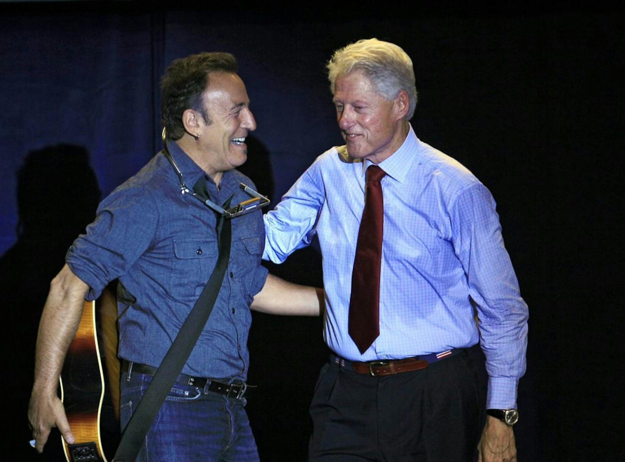 Former President Bill Clinton greets singer/songwriter Bruce Springsteen at a campaign event for President Barack Obama, Thursday, Oct. 18, 2012, in Parma, Ohio.