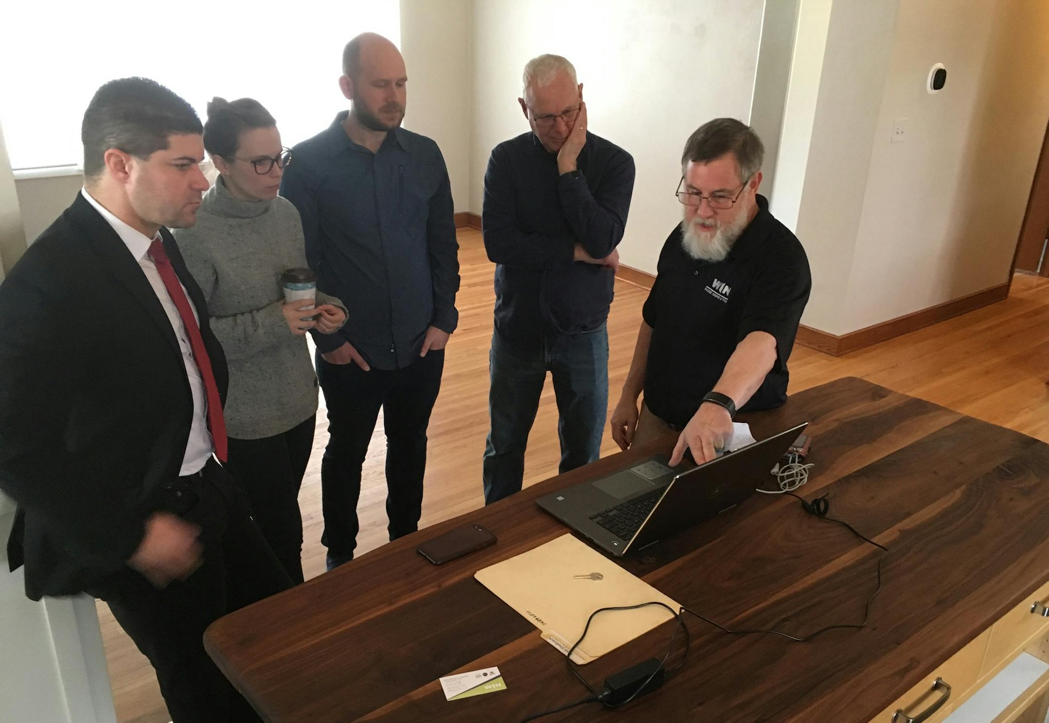 Keller Williams sales agent Nick George (far left) and first-time home buyers, Kate and Matt Shalbrack with Kate's father, Sheldon Matheson (second from right) review an inspection report with Rick Wilson, WIN Home Inspection, for a house they're planning to buy in Roseville.
