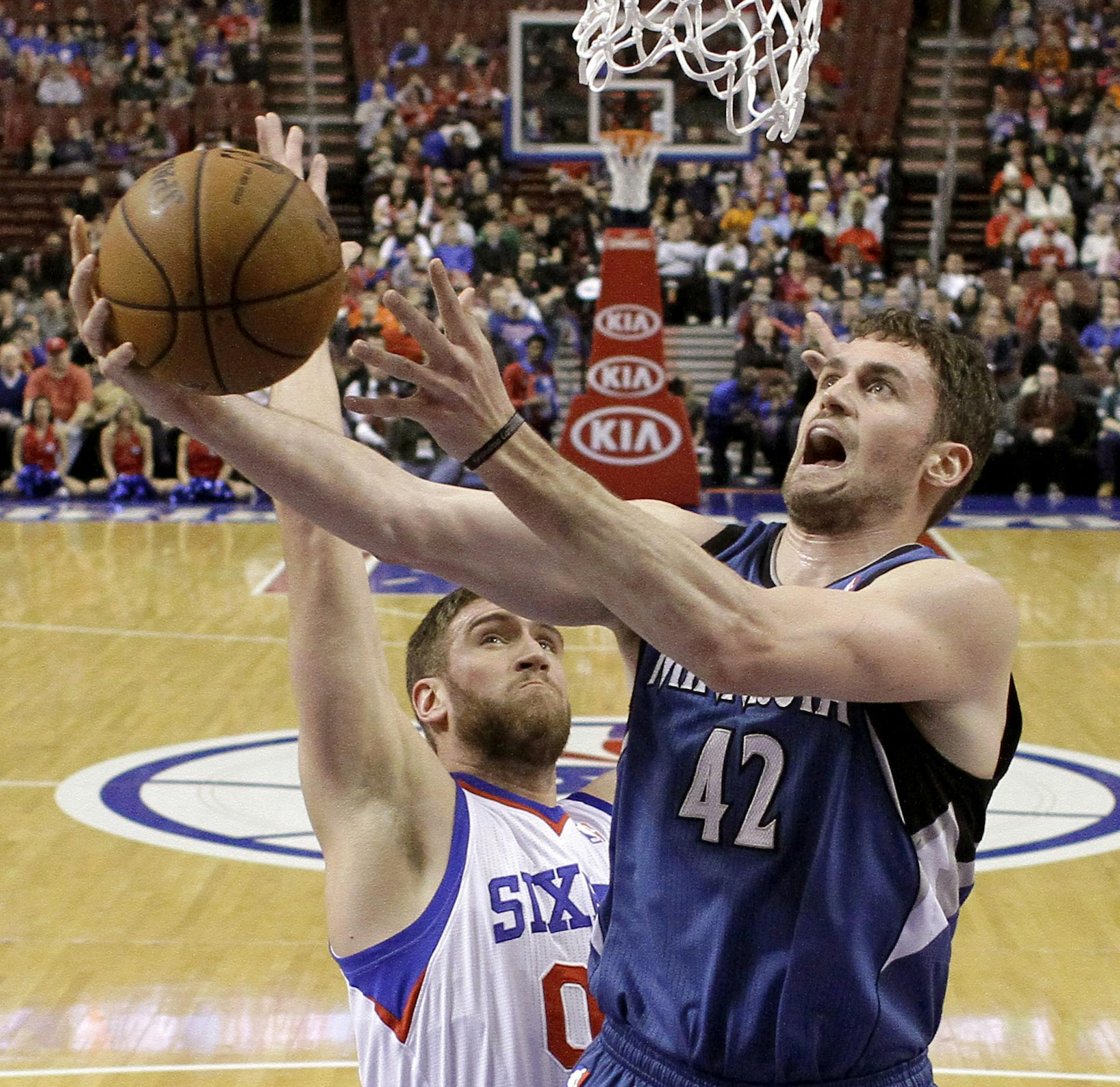 Minnesota Timberwolves' Kevin Love (42) goes up for a shot against Philadelphia 76ers' Spencer Hawes during the first half of an NBA basketball game, Monday, Jan. 6, 2014, in Philadelphia. (AP Photo/Matt Slocum)