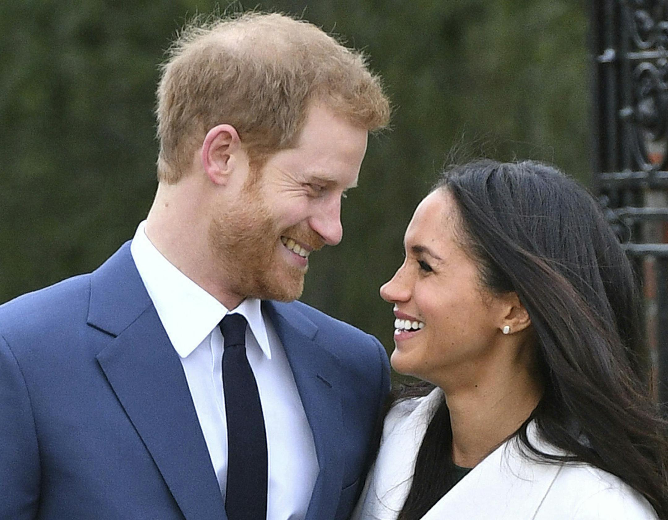 Britain's Prince Harry and Meghan Markle smile as they pose for the media in the grounds of Kensington Palace in London, Monday Nov. 27, 2017. It was announced Monday that Prince Harry, fifth in line for the British throne, will marry American actress Meghan Markle in the spring, confirming months of rumors. (Dominic Lipinski/PA via AP)