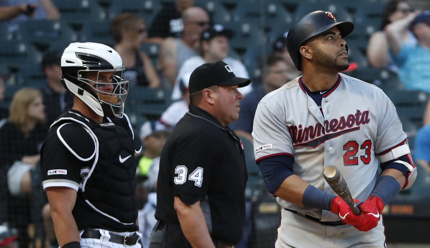 Minnesota Twins' Nelson Cruz (23) watches his second two-run home run as Chicago White Sox catcher James McCann, left, and umpire Sam Holbrook (34) look on during the ninth inning of a baseball game Saturday, June 29, 2019, in Chicago. (AP Photo/Jeff Haynes)