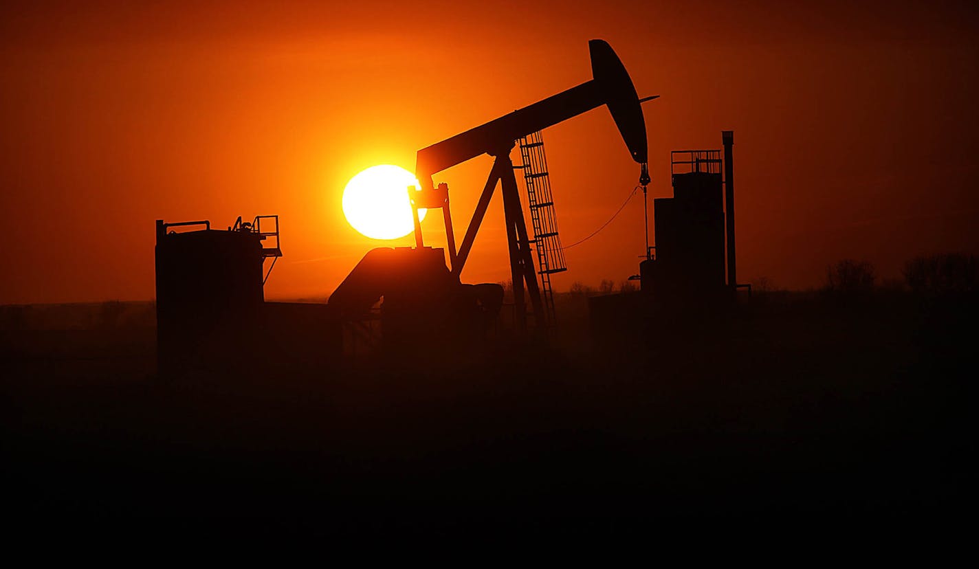 The sun set over the Bakken Oil Formation, behind an oil well near Williston.