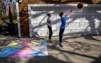 Alessa DiLorenzo, 12, left, and her brother Leo DiLorenzo, 10, played basketball near the chalk art they created in Edina. "It is fun to do when you'r