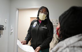 Hennepin Healthcare nurse Tykia Hess and patient Sonia Thompson at the Hennepin Healthcare Downtown Specialty Clinic in December.