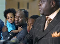 Pierre Collins, at left, holding one of his children.