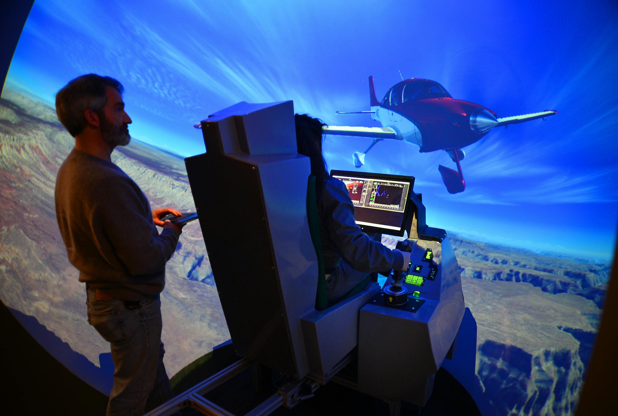 Mike Pohl, who designed this surround-view simulator, worked with student Beckie Moua as she flew a Cirrus aircraft over the Grand Canyon on Wednesday.