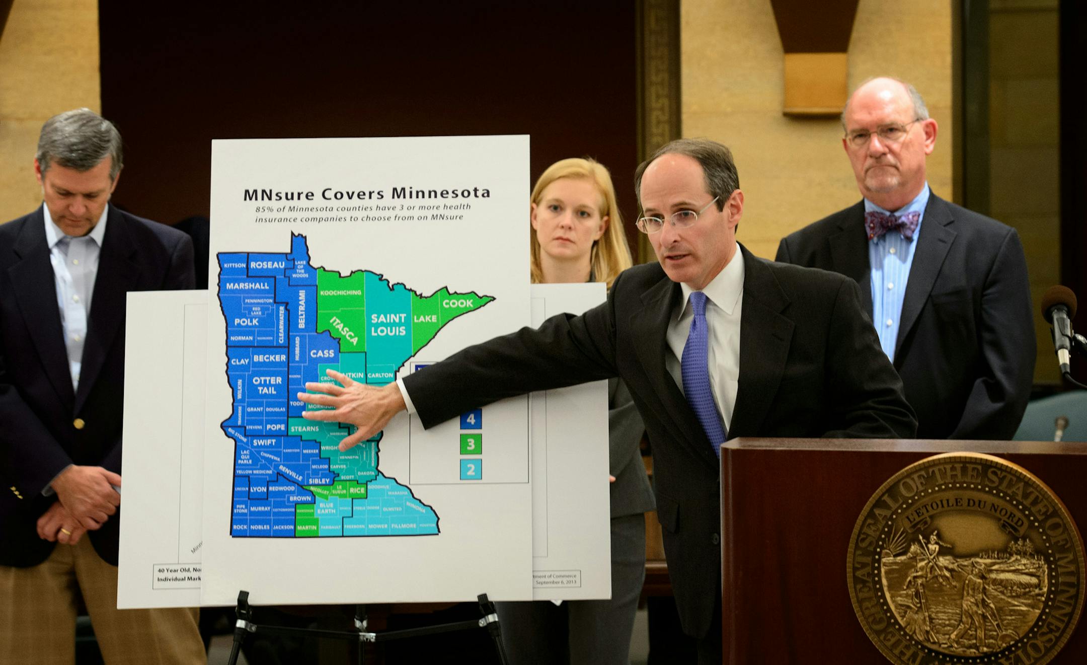 Commerce Commissioner Mike Rothman described the chgoice of companies providing health plans for the regions of the state. Behind him, MNsure chairman Brian Beuther, MNsure director April Todd-Malmov and health commissioner Dr. Ed. Ehlinger. The Commerce Department announced that rates for insurance companies selling plans on the new MNsure exchange, which launches Oct. 1 are the lowest average for in the country, Friday, September 6, 2013 ] GLEN STUBBE * gstubbe@startribune.com