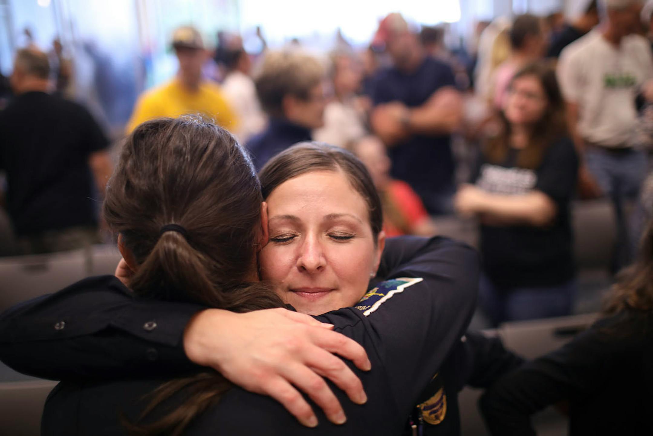 Forest Lake Police Officers Megan Olstad, facing camera, and Nancy Carlson hugged each other after the City Council voted to approve labor contracts with the police department Monday evening.
