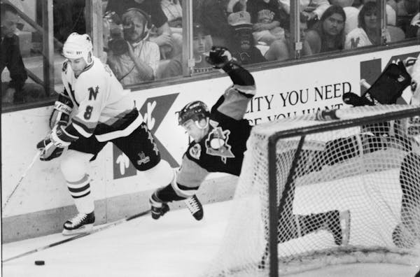 North Stars defenseman Jim Johnson and an unidentified Pittsburgh player battled for a loose puck behind the Stars net during the Stanley Cup Finals i