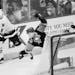 North Stars defenseman Jim Johnson and an unidentified Pittsburgh player battled for a loose puck behind the Stars net during the Stanley Cup Finals i