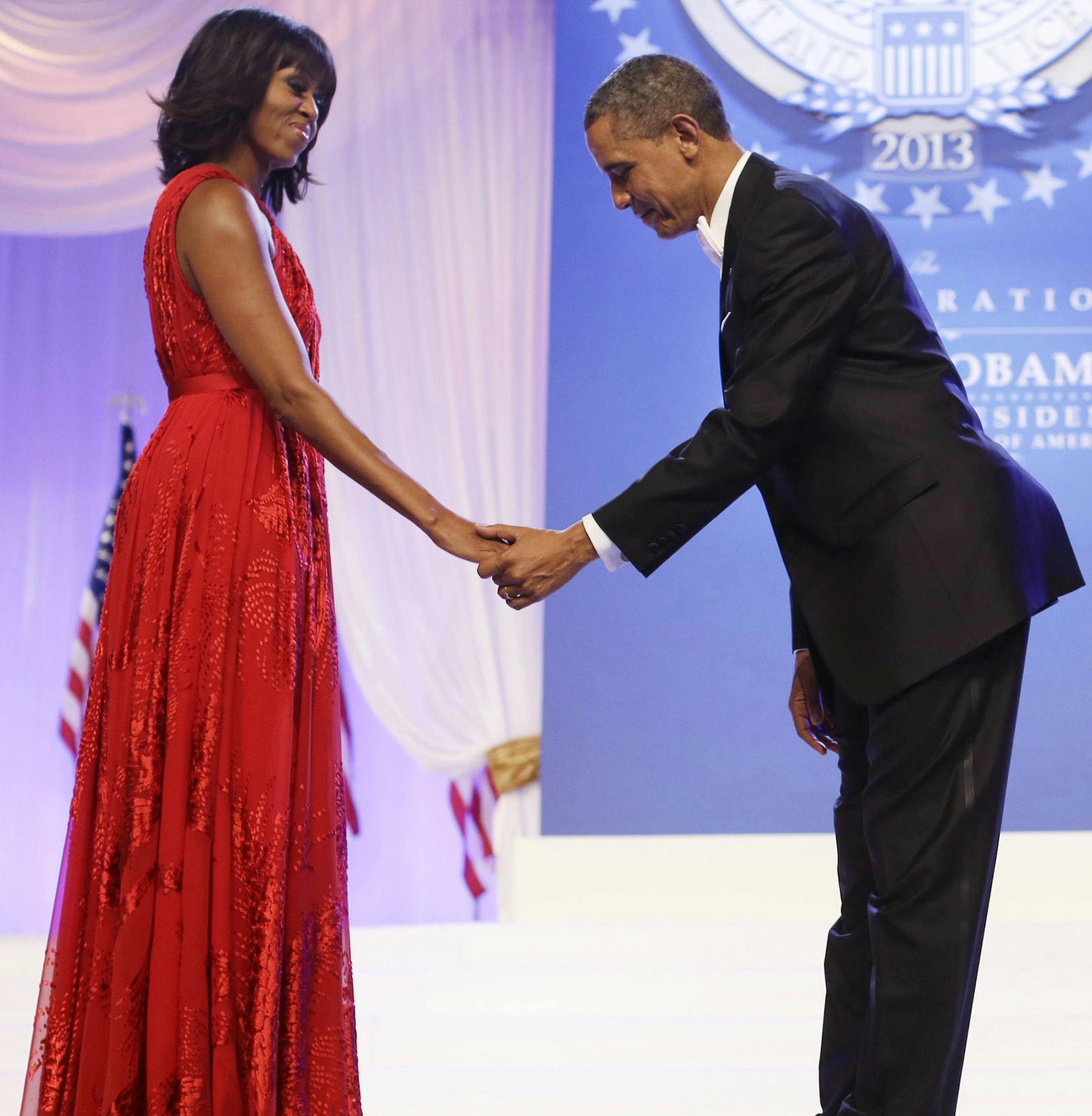FILE - In this Jan. 21, 2013 file photo, President Barack Obama bows as he and first lady Michelle Obama, wearing a ruby-colored chiffon and velvet Jason Wu gown, gets ready to dance at the Inaugural Ball at the Washington Convention Center during the 57th Presidential Inauguration in Washington. Michelle Obama's fashion is making history again, at least for the next year, as her second inaugural gown will be displayed at the Smithsonian Institution. The ruby-colored chiffon gown made by designe
