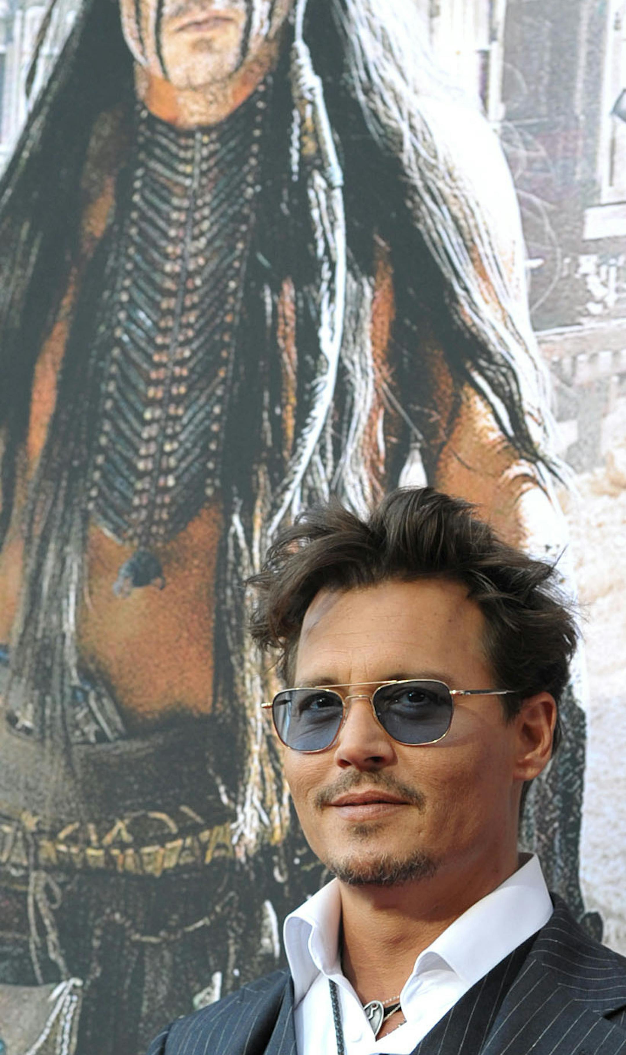In this Saturday, June 22, 2013 photo, Johnny Depp attends the world premiere of "The Lone Ranger" at Disney California Adventure in Anaheim, Calif. The Golden Globe-winning actor plays iconic Native American, Tonto, in the upcoming Disney reboot opening July 3. He said his children, Lily-Rose, 14, and Jack, 11, can&#xed;t wait to see it. (Photo by John Shearer/Invision/AP)