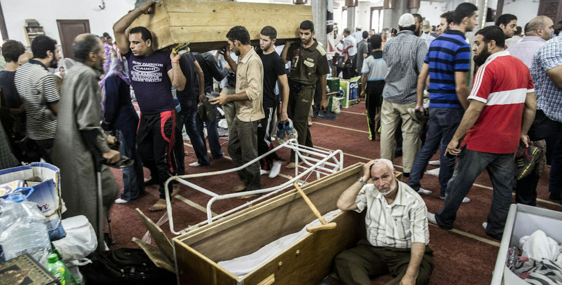 People gather at the El-Iman mosque, where the bodies of pro-Morsi protesters who were killed in Wednesday's government crackdown were brought for identification, in the Nasr City district of Cairo.