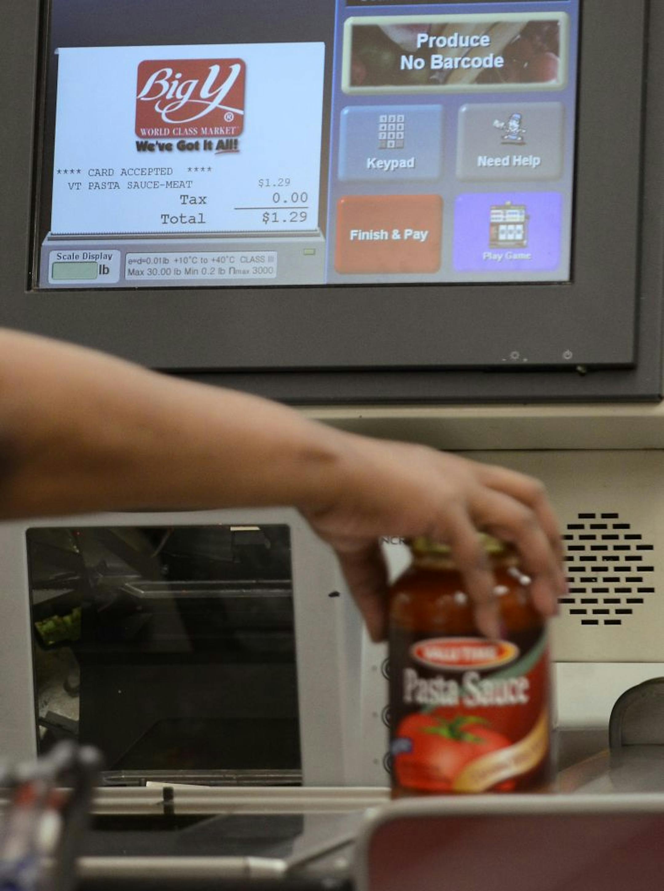 A customer uses a self-serve checkout station at a Big Y supermarket in Manchester, Conn. A growing number of supermarket chains are bagging their self-serve checkout lanes, including Big Y Foods.