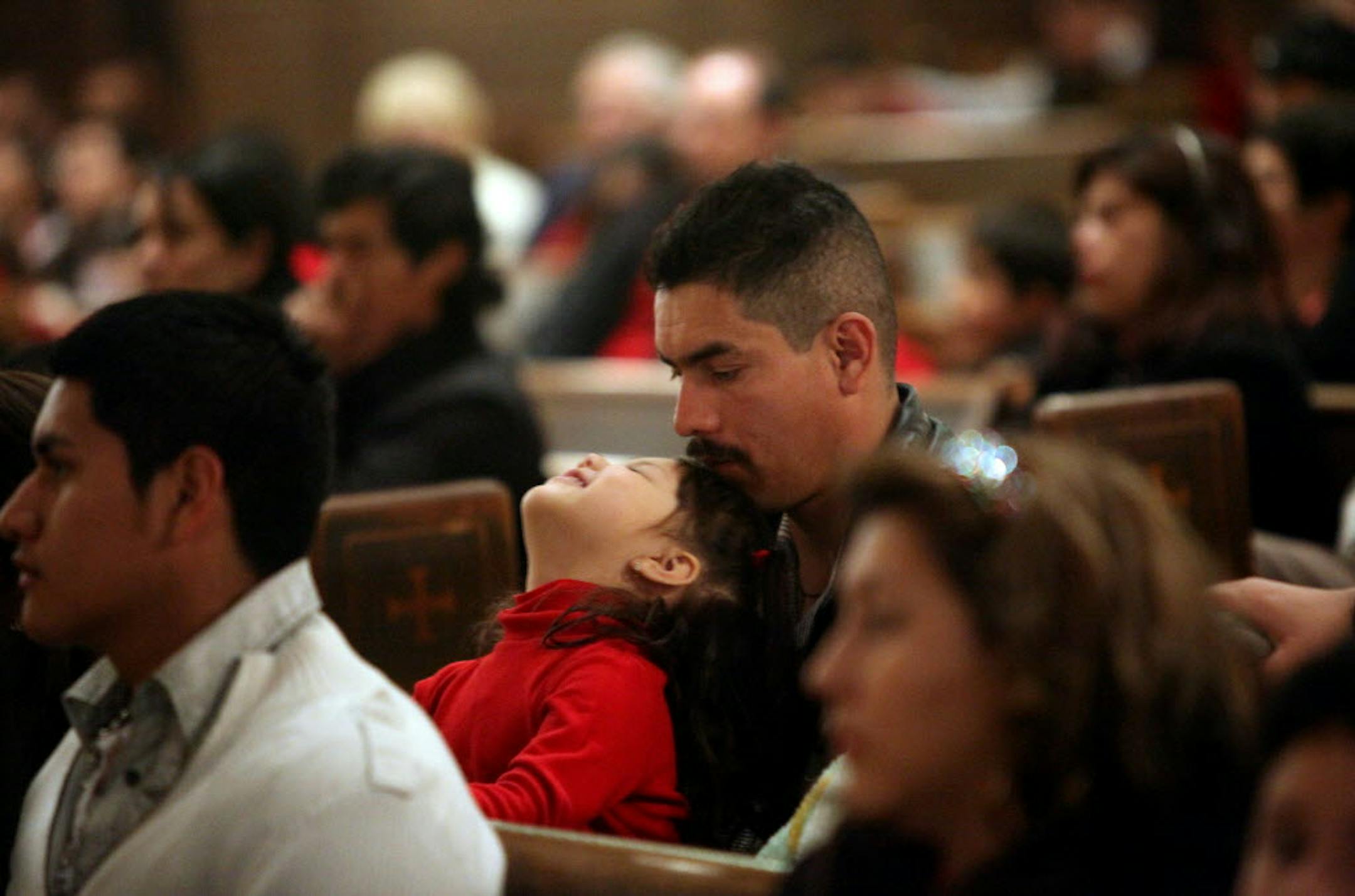 Javier Rosales listened to a speaker with his daughter, Diana, at a vigil for immigrant families at Incarnation Catholic Church in South MInneapolis on Sunday.