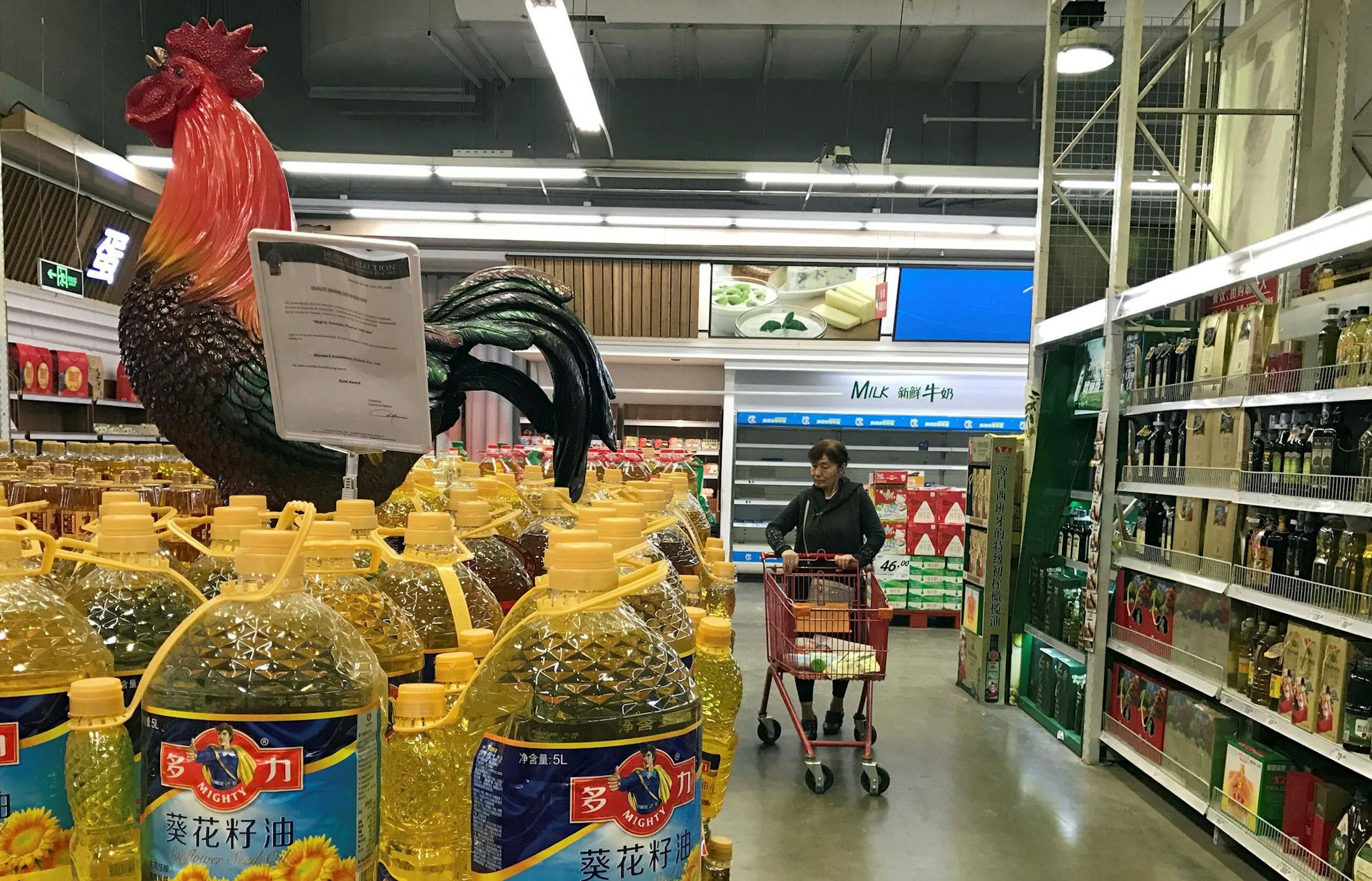In this Friday, March 17, 2017 photo, a shopper pushes a cart down a quiet Lotte Mart in Beijing, China. Chewing-gum maker and retail giant Lotte Group, South Korea's No. 5 business group, took the brunt of the backlash after agreeing to let one of its golf courses in southeastern South Korea be a site for deploying the Terminal High-Altitude Area Defense system, or THAAD. At least 55 of 99 Lotte Mart discount stores in China were shut in early March for a month each after surprise inspections f