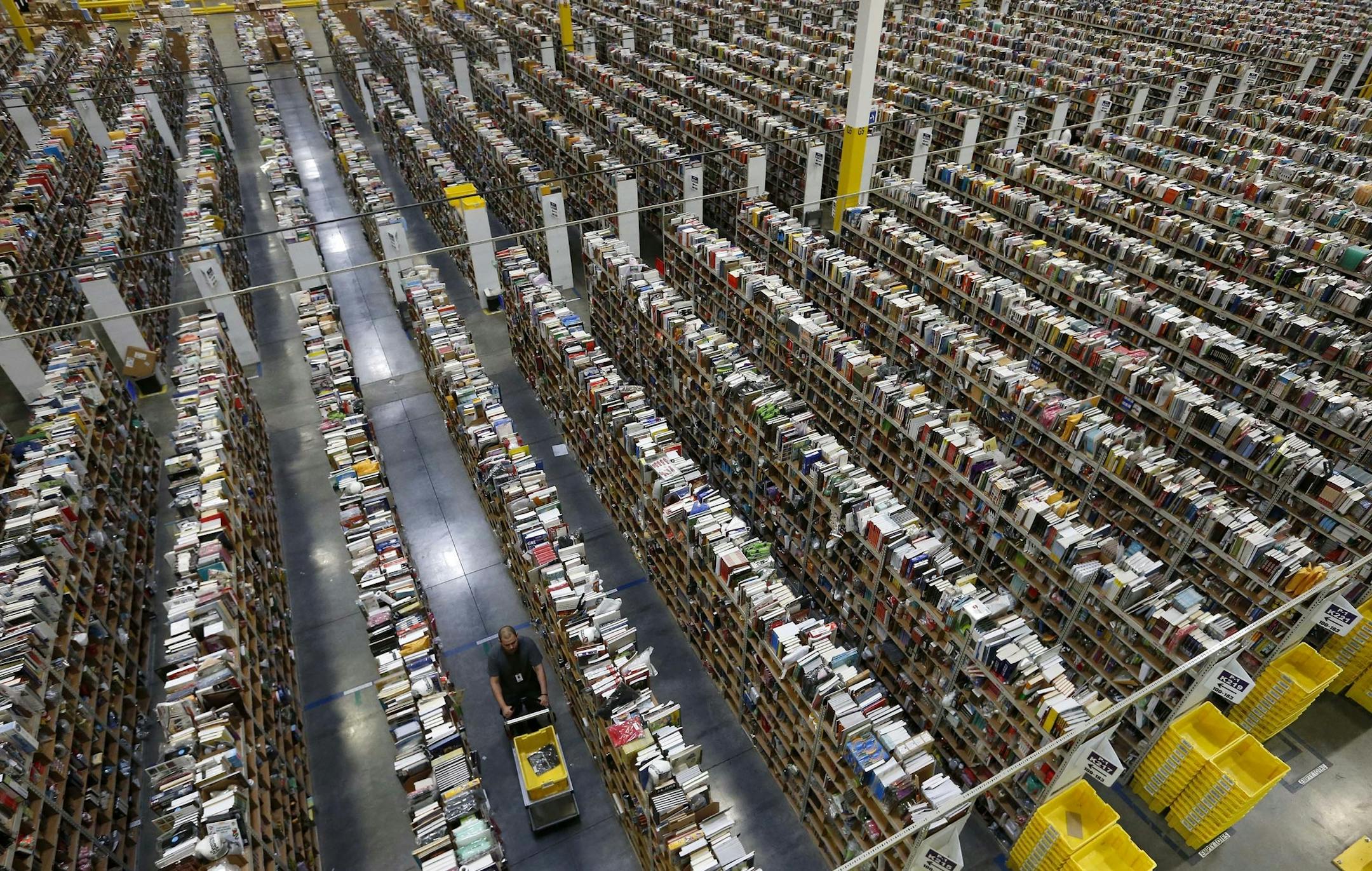 An Amazon.com employee walks down one of the miles of aisles at an Amazon.com Fulfillment Center on "Cyber Monday" on the busiest online shopping day of the holiday season Monday, Dec. 2, 2013, in Phoenix. (AP Photo/Ross D. Franklin)