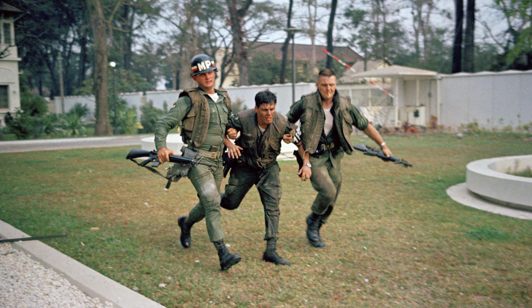 FILE - In this Jan. 31, 1968, file photo, two U.S. military policemen aid a wounded fellow MP during fighting in the U.S. Embassy compound in Saigon, Vietnam, at the beginning of the Tet Offensive. A Viet Cong suicide squad seized control of part of the compound and held it for about six hours before they were killed or captured. Early on the morning of Jan. 31, 1968, as Vietnamese celebrated the Lunar New Year, or Tet as it is known locally, Communist forces launched a wave of coordinated surpr