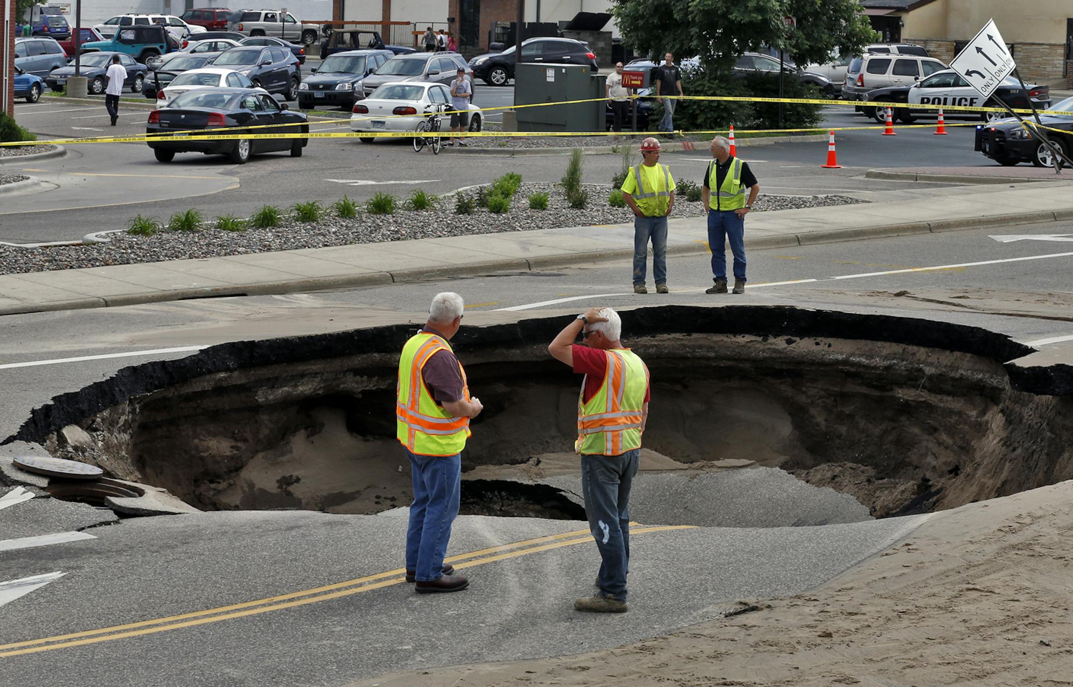 Sink hole in middle of 42 Ave. N. at Bottineau Blvd. caused by a broken water main. Robbinsdale city workers assess the damage done by the sink hole. (MARLIN LEVISON/STARTRIBUNE(mlevison@startribune.com (cq )