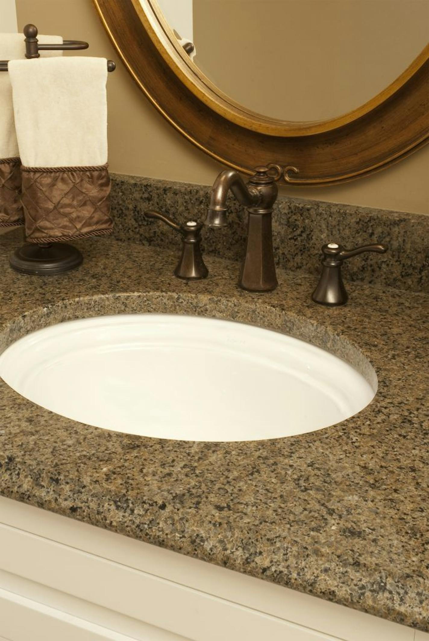 The project's earth-tone hues are in the granite vanity top and oil-rubbed bronze fixtures,