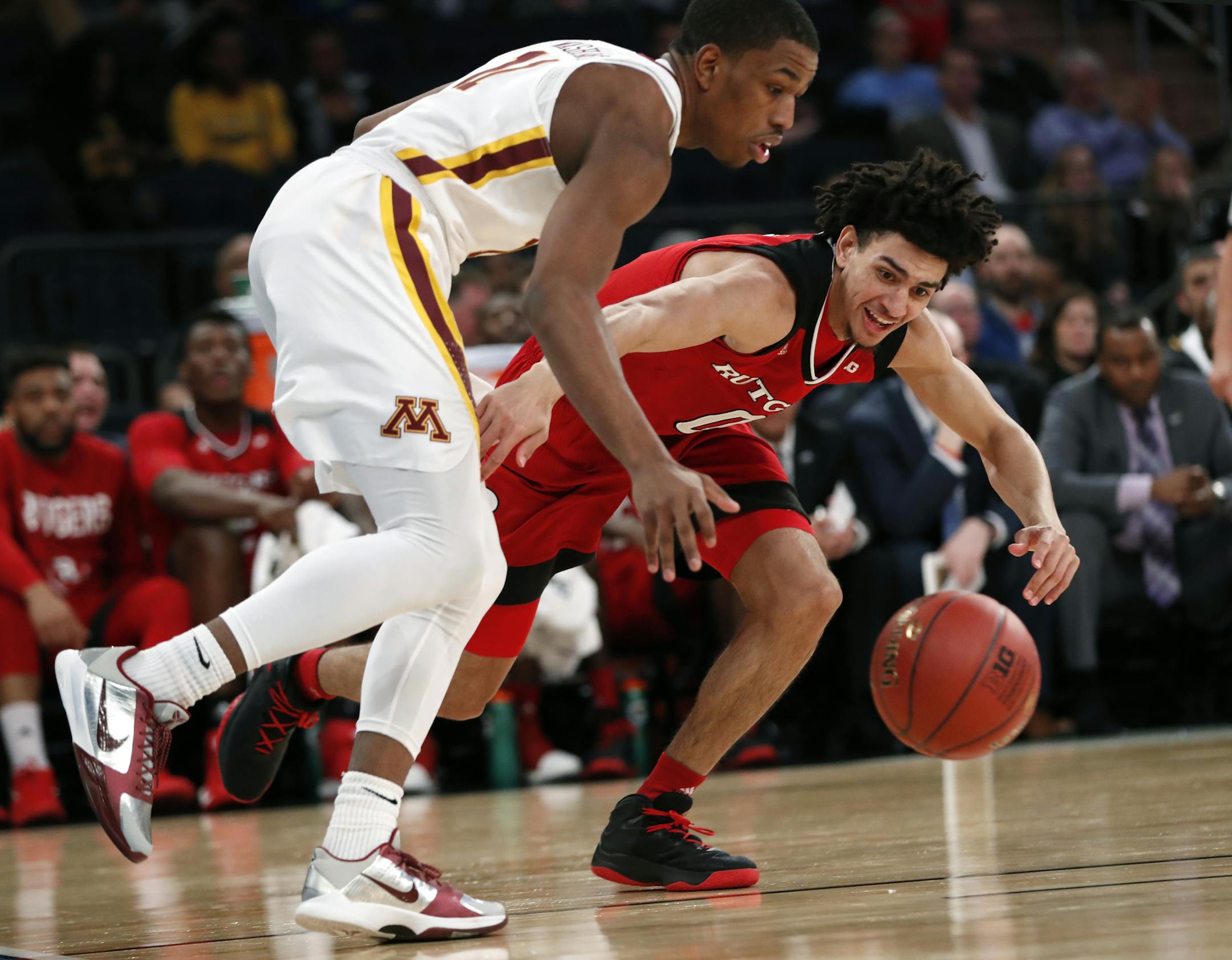 Rutgers guard Geo Baker (0) and Minnesota guard Isaiah Washington (11) go after a loose ball after Washington lost control of it during the first half of an NCAA college basketball game in the first round of the Big Ten men's tournament, Wednesday, Feb. 28, 2018, in New York. (AP Photo/Kathy Willens)