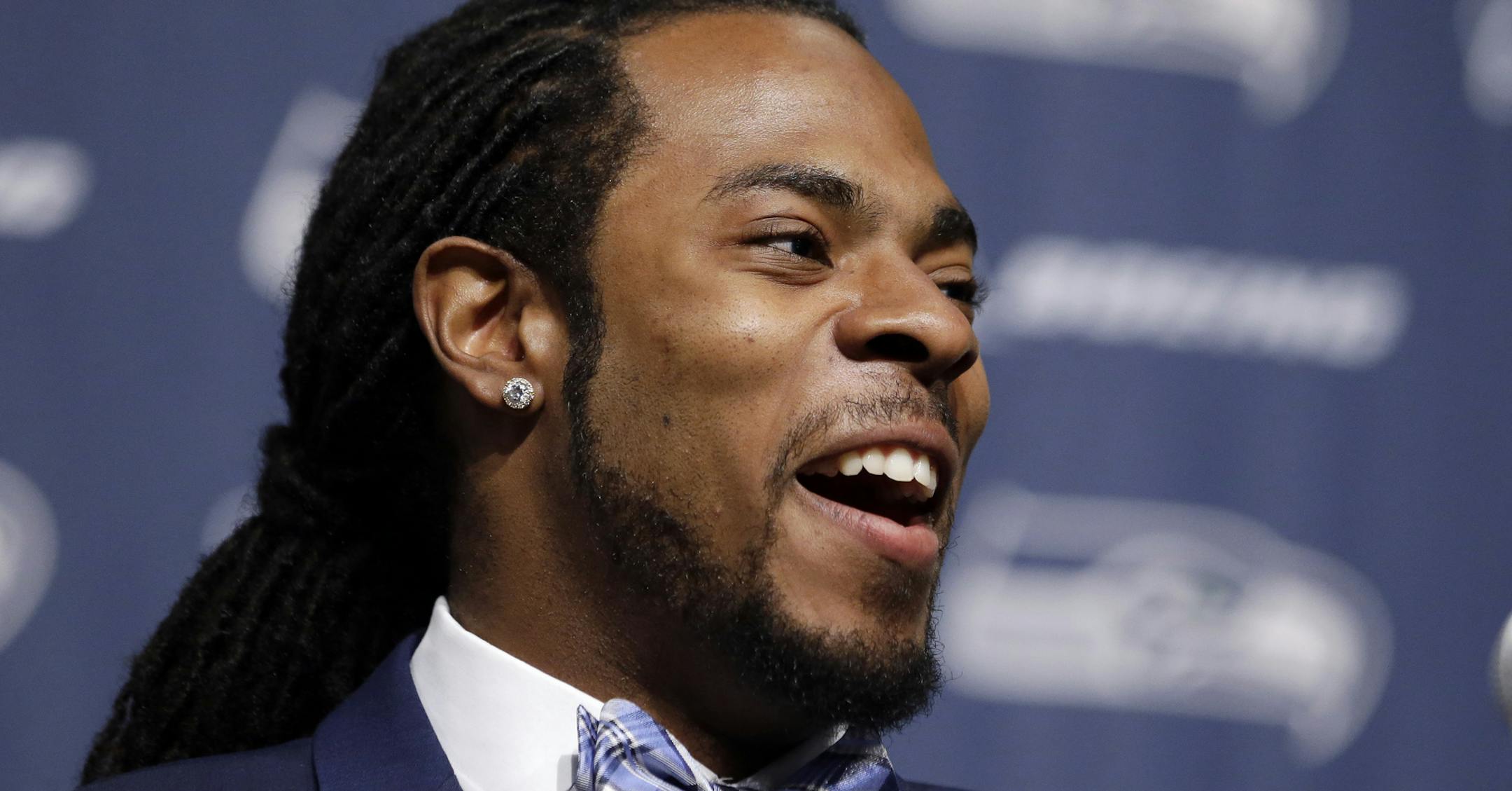 Seattle Seahawks' Richard Sherman smiles as he addresses a news conference Wednesday, May 7, 2014, at the team's headquarters in Renton, Wash. Sherman signed a four-year contract extension Wednesday with the Seahawks, a deal that makes him one of the highest-paid cornerbacks in NFL history. Sherman announced the deal on his website and later confirmed the new deal will keep him in a Seahawks uniform through the 2018 season. Sherman wrote that the extension is for $57.4 million with $40 million g