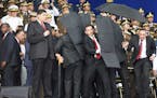 In this photo released by China's Xinhua News Agency, security personnel surround Venezuela's President Nicolas Maduro during an incident as he was gi