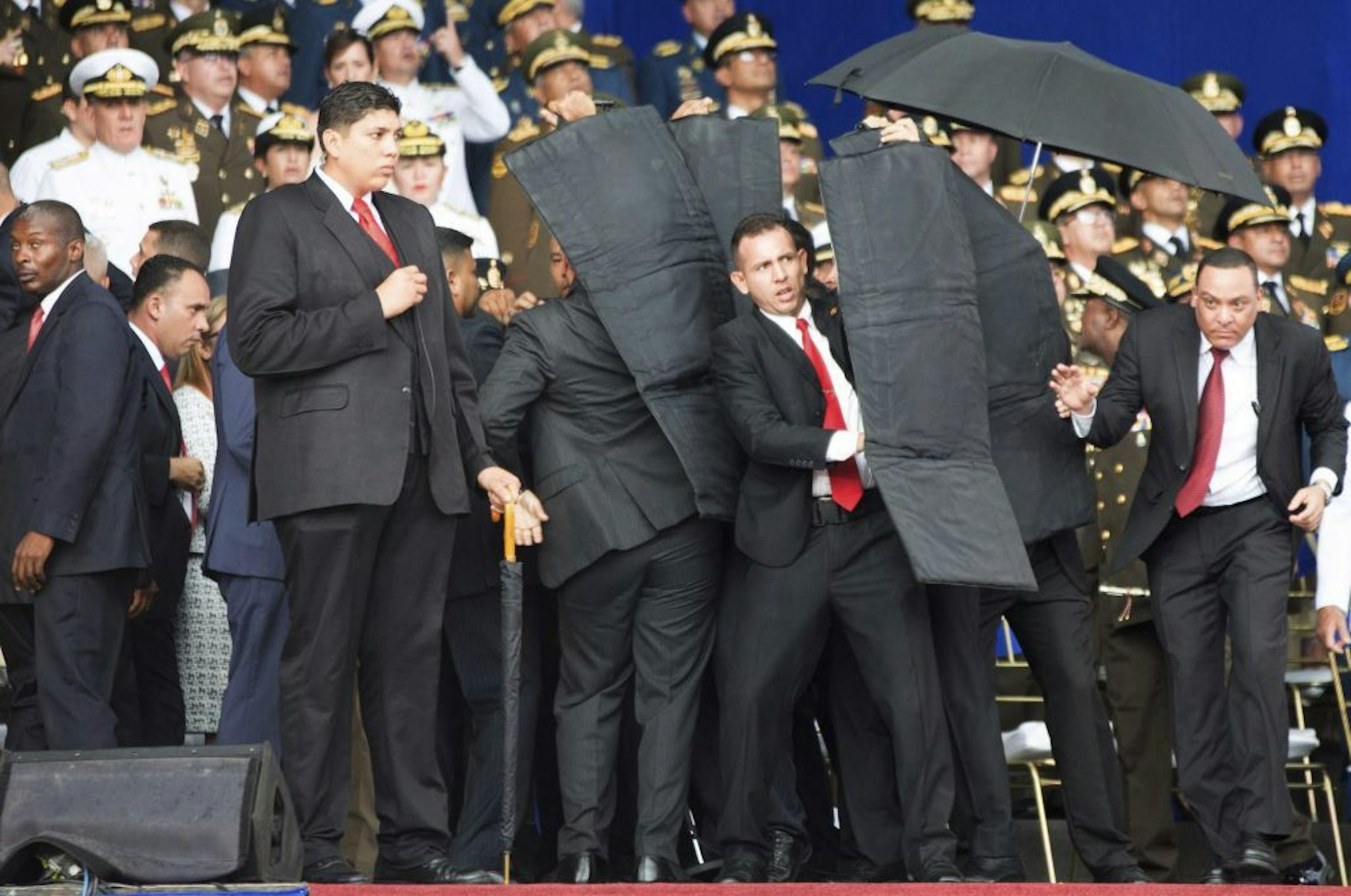 In this photo released by China's Xinhua News Agency, security personnel surround Venezuela's President Nicolas Maduro during an incident as he was giving a speech in Caracas, Venezuela, Saturday, Aug. 4, 2018. Drones armed with explosives detonated near Venezuelan President Nicolas Maduro as he gave a speech to hundreds of soldiers in Caracas on Saturday but the socialist leader was unharmed, according to the government.