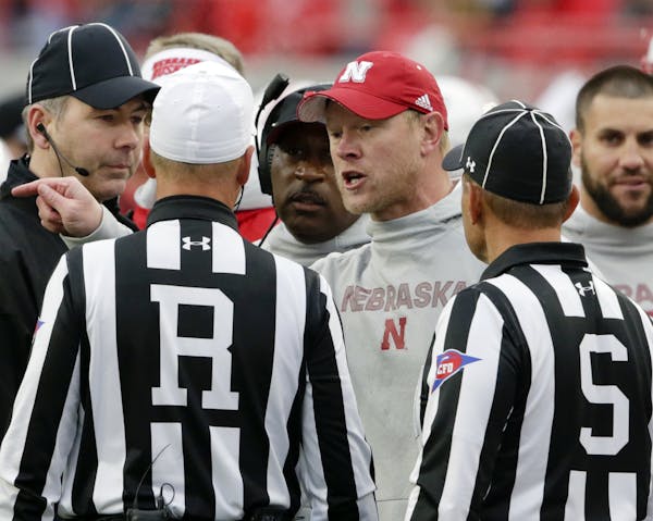 Nebraska head coach Scott Frost, center, exchanges words with Referee Ron Snodgrass and side judge Dominique Pender (S), during the second half of an 