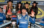 Jimmie Johnson poses for photos in victory lane after winning the NASCAR Sprint Cup Series auto race at Texas Motor Speedway in Fort Worth, Texas, Sun