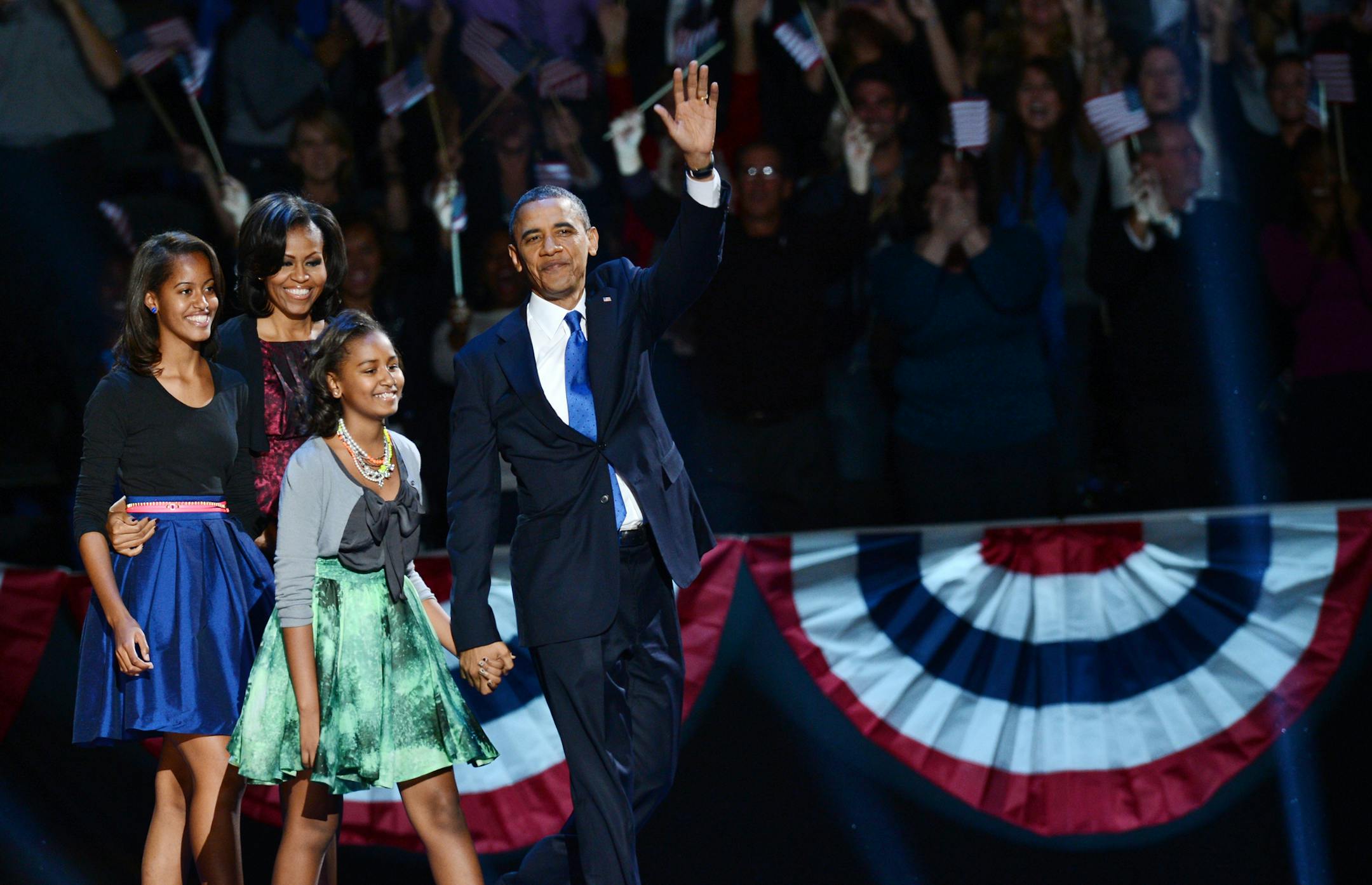 US President Barack Obama and family arrive on stage after winning the 2012 US presidential election November 7, 2012 in Chicago, Illinois. Obama swept to re-election, forging history again by defying the dragging economic recovery and high unemployment which haunted his first term to beat Republican Mitt Romney. AFP PHOTO / Saul LOEB (Photo credit should read SAUL LOEB/AFP/Getty Images)