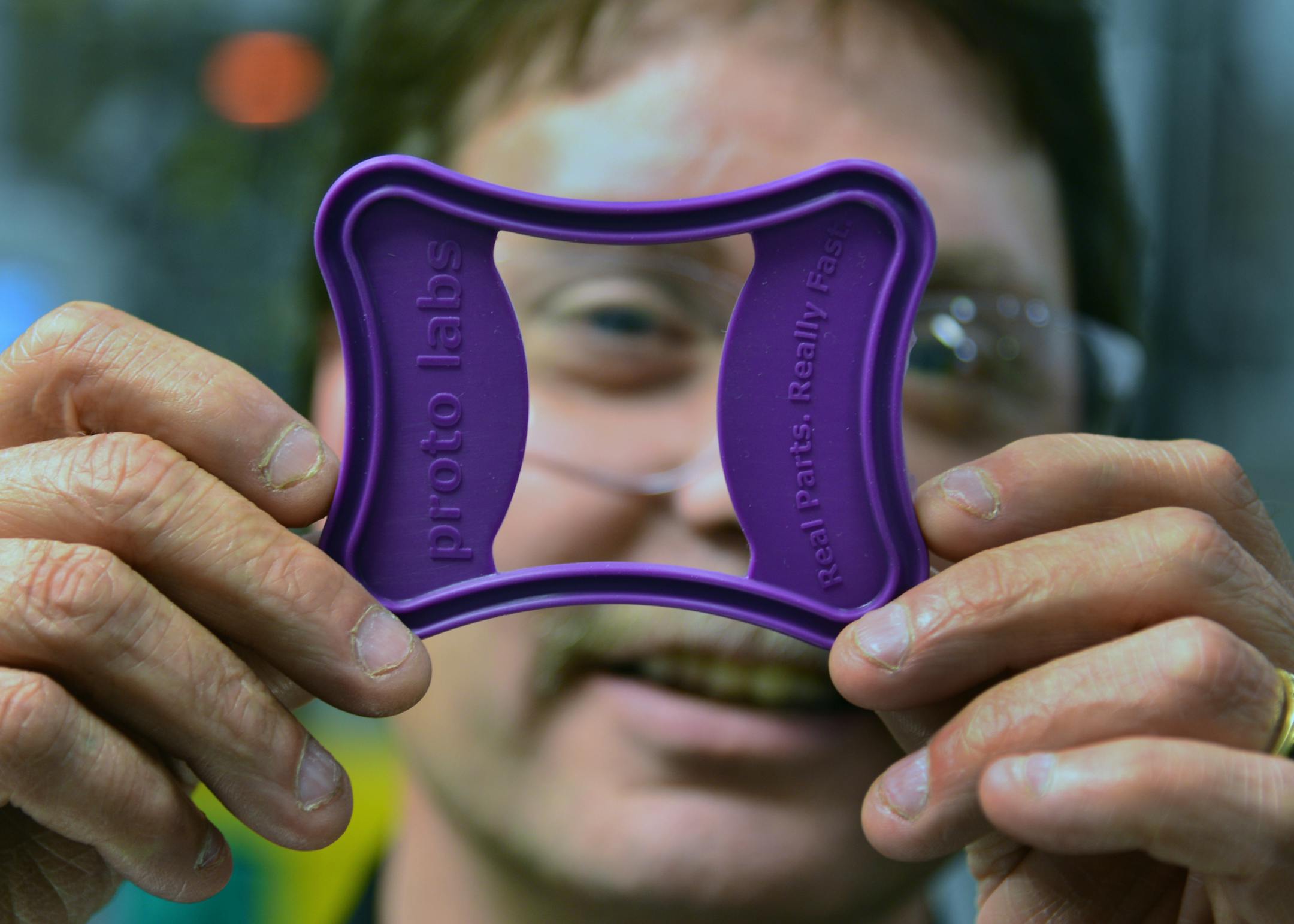 Daren Braun looked through a promotional part in a manufacturing area of Proto Labs. ] Proto Labs invested $3 million and now will offer steel and rubber injection molding services in addition to its traditional plastic contract-manufacturing work. New business division will be in Maple Plain, Minn Richard.Sennott@startribune.com Richard Sennott/Star Tribune Maple Plain Minn. FRiday 4/11/2014) ** (cq)