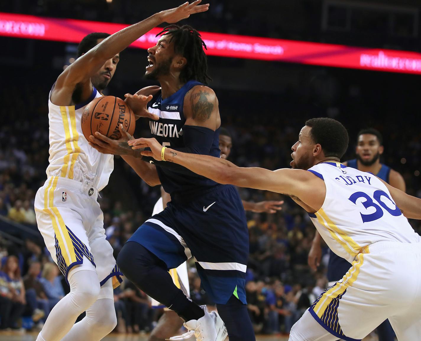 The Timberwolves' Derrick Rose, center, drives the ball against Golden State's Shaun Livingston, left, and Stephen Curry