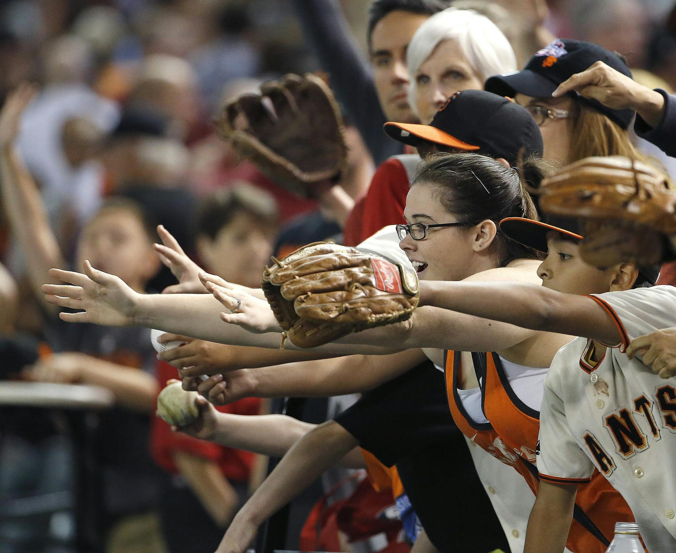 San Francisco Giants fans try to get autographs or a baseball tossed their way after an opening day baseball game against the Arizona Diamondbacks Monday, April 6, 2015, in Phoenix. The Giants defeated the Diamondbacks 5-4. (AP Photo/Ross D. Franklin)