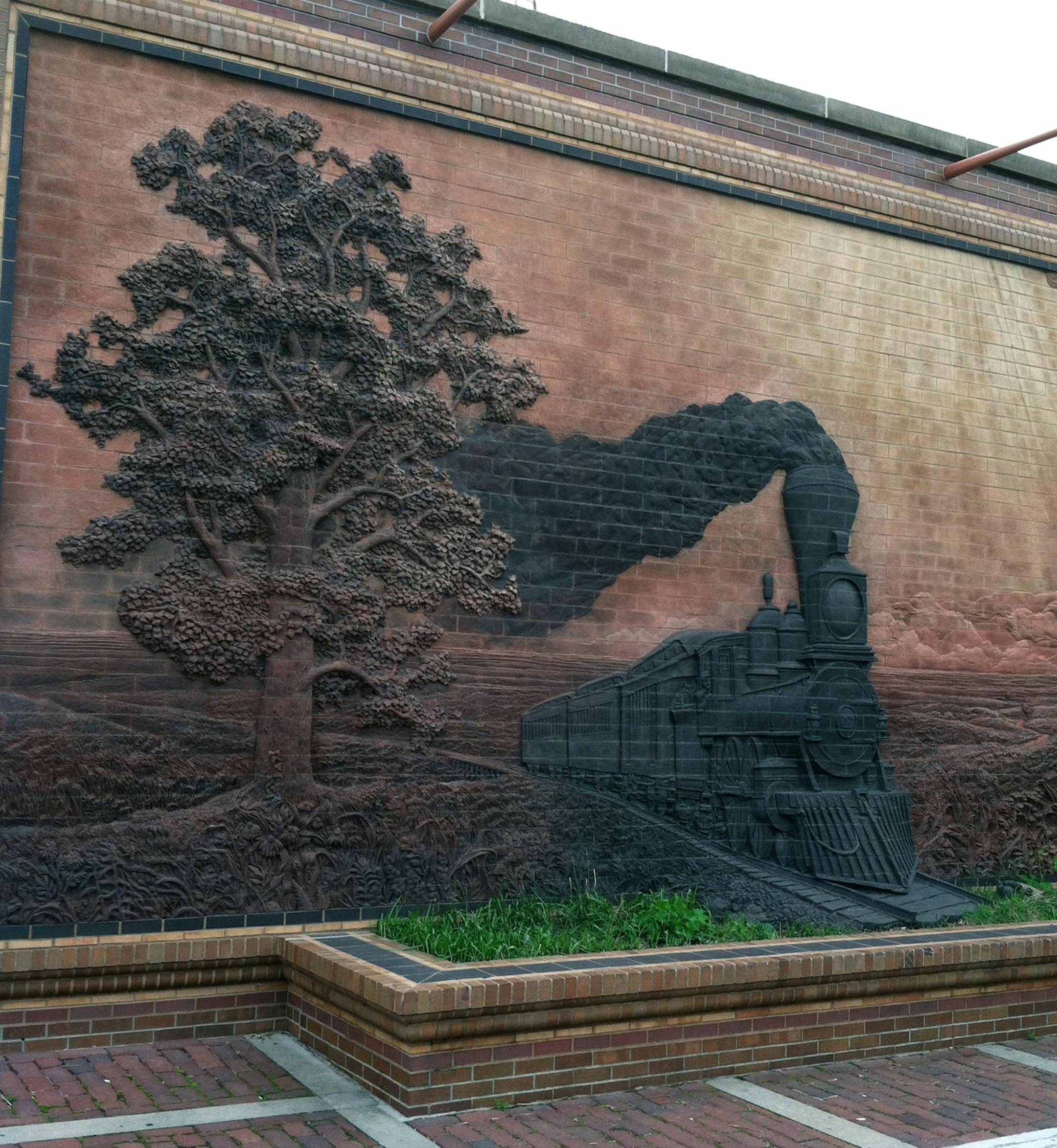 The piece “Iron Horse Legacy” near the Historic Haymarket water tower in Lincoln, Neb., seems to come chugging out of the wall.
