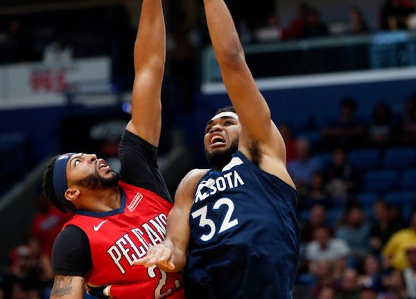 Minnesota Timberwolves center Karl-Anthony Towns (32) goes to the basket against New Orleans Pelicans forward Anthony Davis during the first half of a