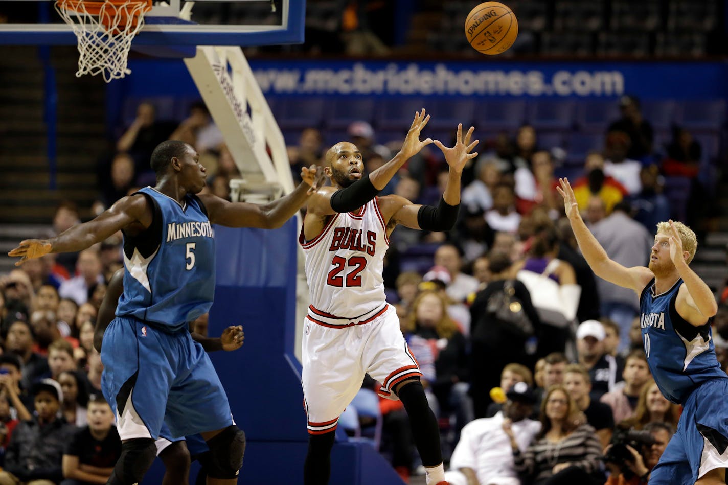 Chicago Bulls' Taj Gibson, center, reaches for the ball alongside Minnesota Timberwolves' Gorgui Dieng, left, and Chase Budinger during the second half of a preseason NBA basketball game Friday, Oct. 24, 2014, in St. Louis. The Timberwolves won 113-112. (AP Photo/Jeff Roberson)