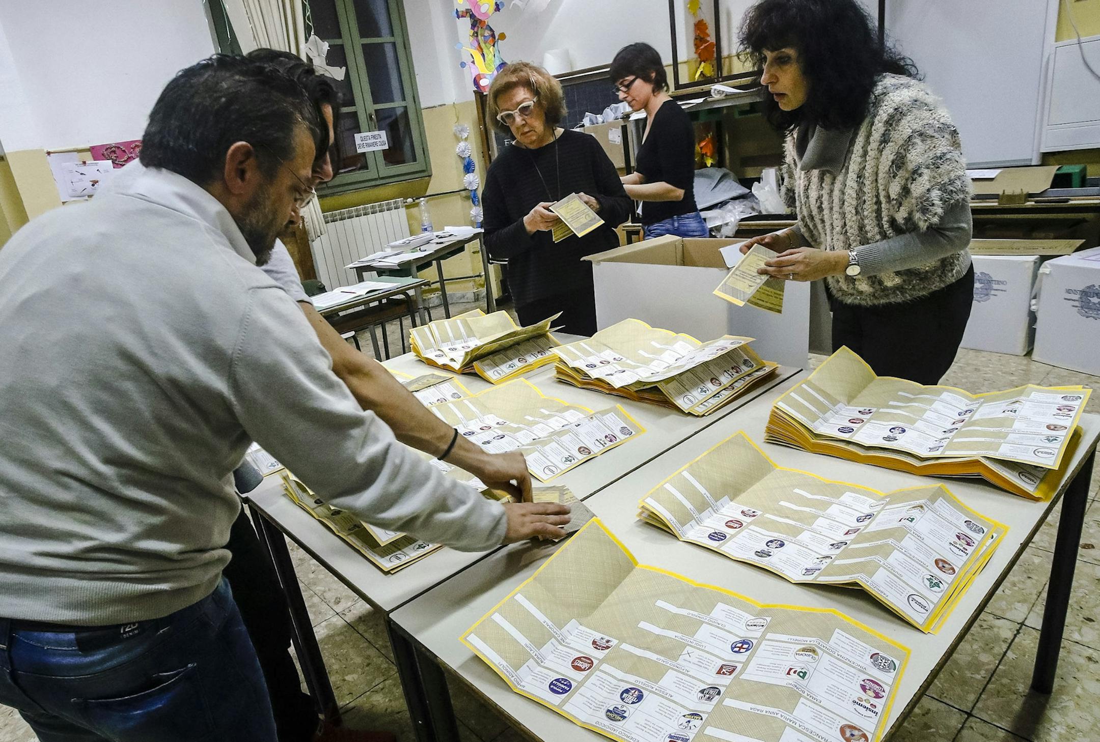 Scrutineers count votes in a polling station in Rome, Sunday, March 4, 2018, at the end of the general election day in Italy. The campaign was marked by the prime-time airing of neofascist rhetoric and anti-migrant violence that culminated in a shooting spree last month against six Africans. While the center-right coalition that capitalized on the anti-migrant sentiment led the polls, analysts predict the likeliest outcome is a hung parliament. (Giuseppe Lami/ANSA via AP)